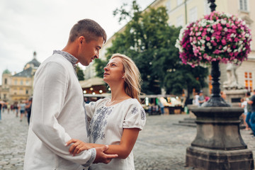 Loving couple walking in old Lviv city wearing traditional national ukrainian shirts. Newlyweds spend time together