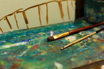 Brushes on an easel stained with paints in the artist's studio