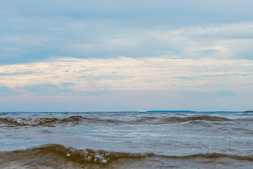 Deep cold blue water of Ladoga lake with sun light reflections under blue cloudy sky
