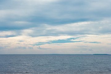 Naklejka na ściany i meble Deep cold blue water of Ladoga lake with sun light reflections under blue cloudy sky