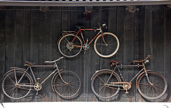 vecchie biciclette appese alla parete di un fienile