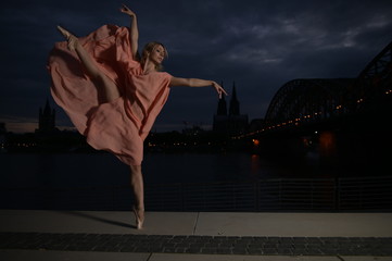 A beautiful ballet dancer ballerina outdoors ,Ballerina dancing on the bridge  in Cologne City .