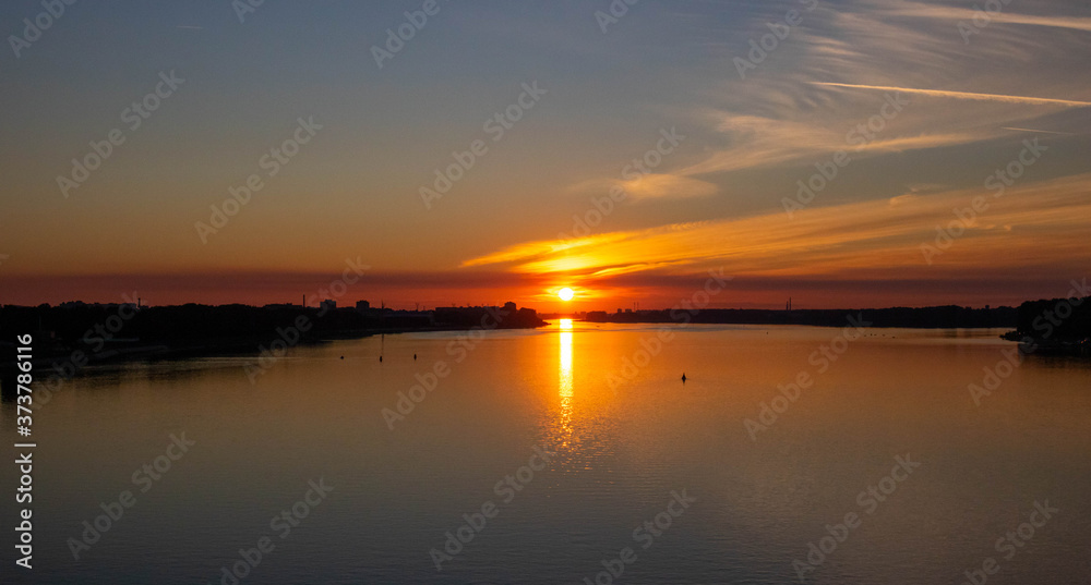 Wall mural orange sunset over the river on a summer evening