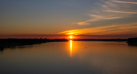 Fototapeta na wymiar Orange sunset over the river on a summer evening