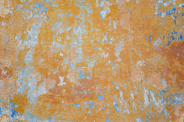 Fototapeta premium Texture of old wall with shabby orange and blue paint. Background