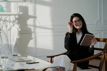businesswoman talking on phone in office. the concept of a businesswoman. Glasses on the face for protection from the monitor.
