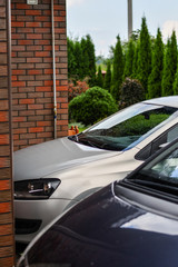 Front part of the cars parked in front of the garage door. Selective focus.