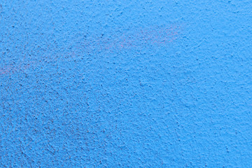 The plaster rough wall is painted blue
