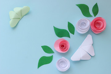 Origami paper background with butterflies, flowers and leaves. With place for text. Origami composition. Paper craft