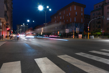 Fototapeta na wymiar Timelapse view of traffic at an urban night intersection. Urban movement in the Italian city in the evening.