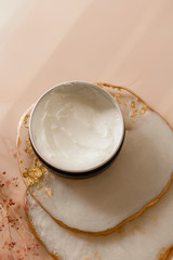 Cosmetic cream texture in a jar on pastel background