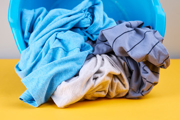 stack of a colored clothes for laundry cleaning and washing service. background backdrop. copy space. studio shoot. laundry concept