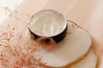 Cosmetic cream texture in a jar on pastel background