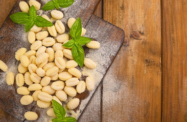 Gnocchi with potatoes. Traditional italian food from Rome, Sardinia, south of italy. Homemade gnocchi with parmesan, egg, cornmeal (semolina). On a wooden table. High quality photo. Above. Copy space 