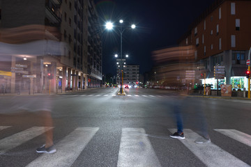 Fototapeta premium Timelapse view of traffic at an urban night intersection. Urban movement in the Italian city in the evening.
