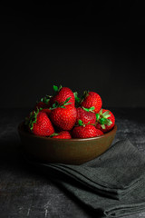 strawberries in a bowl on a wooden table