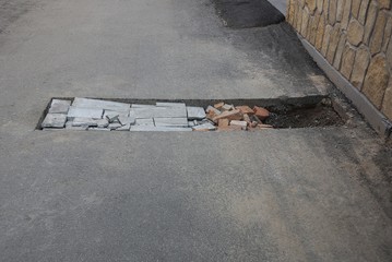 one rectangular pit pothole on the asphalt road on the street