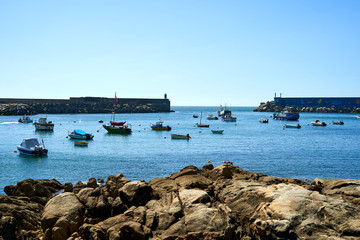 seaport with blue waters and moored boats, with orange stones. Seaport with entrance to the sea and boats