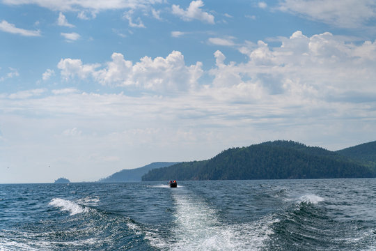 Russia, Irkutsk region, Baikal lake, July 2020: splashy boat tracks on water of baikal lake