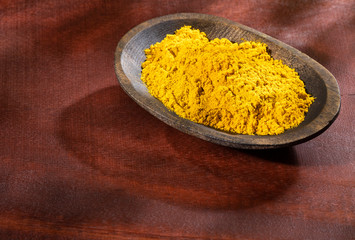 Organic curry powder in the wooden bowl - Text space
