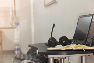 Headphones are on the desk in the house with laptop and working accessory place nearby