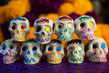 Calaveras de azúcar en fondo de cempasúchil y papel picado ofrenda día de muertos decoración tradición ancestral mexicana 