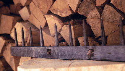Fototapeta premium old wooden rake on a background of wood stack