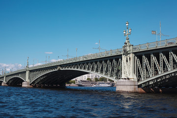 Historic forged bridge above Neva river in Saint Petersburg on sunny day