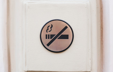 No smoking sign, metallic plate on a wall, toned