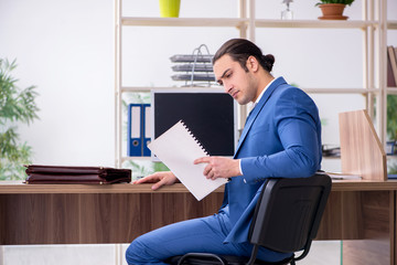 Fototapeta premium Young male employee businessman at workplace