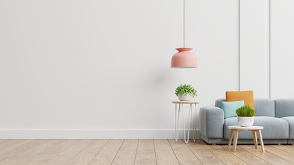 Empty living room with blue sofa, plants and table on empty white wall background.