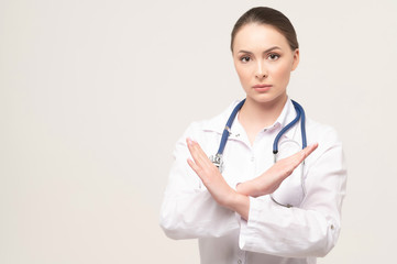 Portrait of an attractive young female doctor showing stop gesture