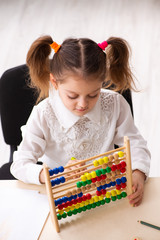 Small girl with abacus in the classroom
