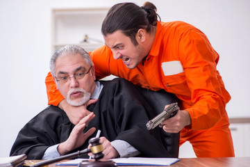 Old male judge meeting with young captive in courthouse