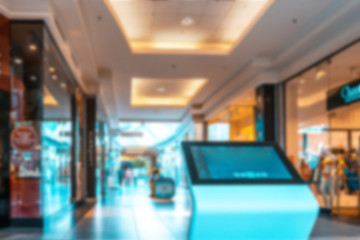 Shopping mall interior blurred background. People shopping in modern commercial mall center. Interior of retail centre store in soft focus. Image for background use.