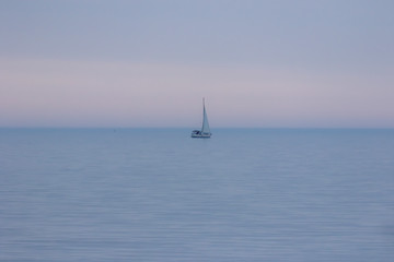 The sailboat in the evening haze on the lake Michigan.