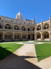 Fototapeta premium Inside the beautiful Hieronymites Monastery of Jeronimos with the beautiful green garden in Belem, Lisbon, Portugal