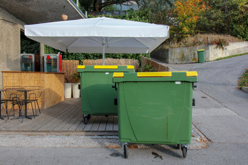 green plastic trash containers, residential area new building.