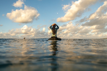 Surfer girl at sunset, Byron Bay Australia