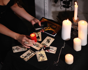 Dark flat lay of witchy items. Tarot cards spread. Forecasting wicca, occult, esoteric, divination and mistic concept. Magic rituals.