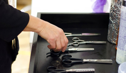 Hands of a woman grabbing scissors