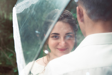 Portrait of a happy bride with a transparent wedding umbrella