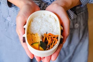 手作りのお弁当を持つ女性