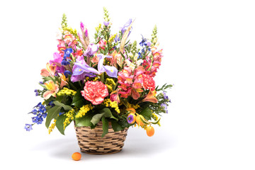 bouquet of bright flowers in basket isolated on white background. Mothers Day or Valentines Day...