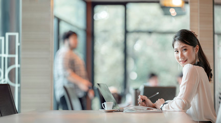 Young beautiful asian businesswoman sitting at the table in meeting room while working with laptop.