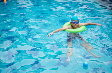 Boy practicing swimming in the pool.