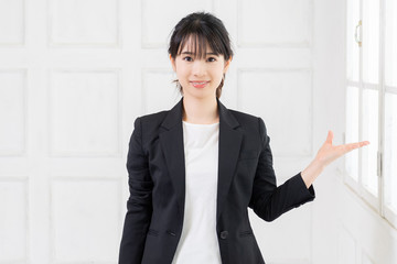 案内のジェスチャーをする若い女性