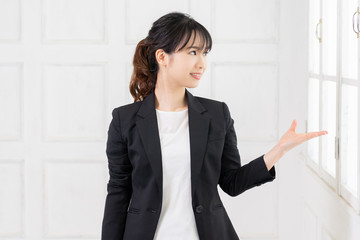 案内のジェスチャーをする若い女性