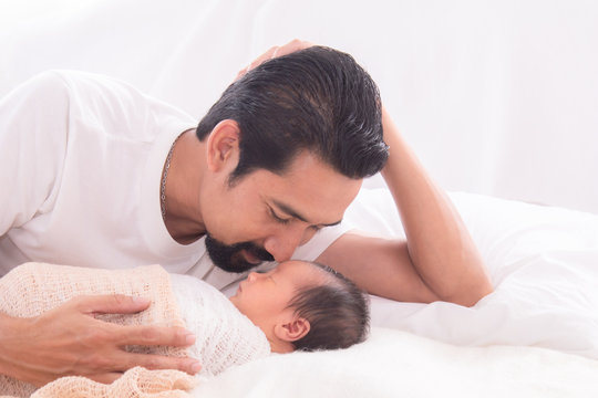 Handsome Happy Asian Men With Beard Dad Kissing Healthy Toddler Newborn Baby In Bed At Home, Healthcare Medical Lifestyle Father Day/ Parenthood Concept, Infant Sleep  Safe And Protection Bonding