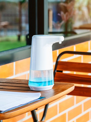 Automatic alcohol dispenser for cleaning hand to prevent the spreading of Coronavirus (Covid-19) on table before entrance to cafeteria. Healthcare concept. New normal lifestyle. Selective focus